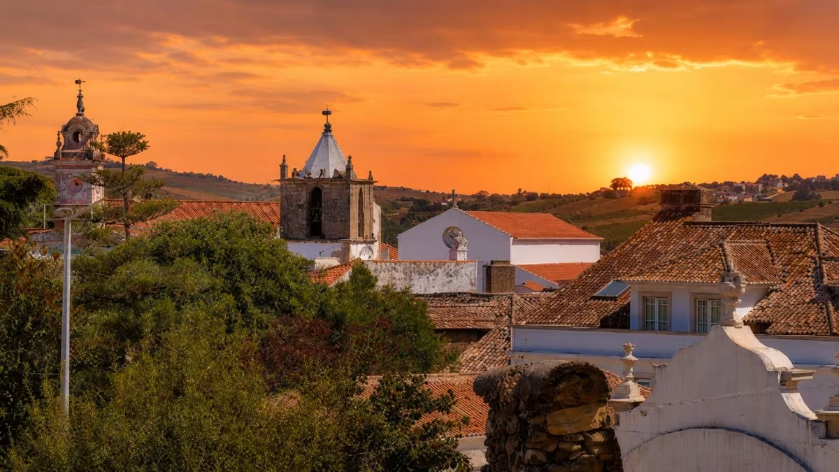 Vista dos telhados e torre da igreja de Arruda dos Vinhos ao pôr-do-sol